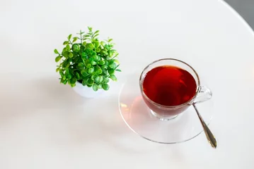 Fotobehang rose tea in cup on white table, red tea © Jittapisut