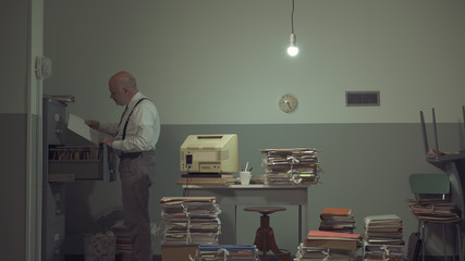 Businessman searching for files in a messy office