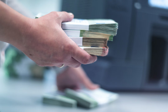 Bank Employees Sorting And Counting Money Inside Bank Vault.