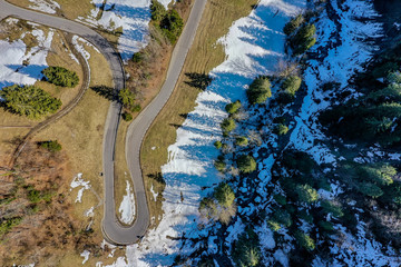 Kurvige Strasse mit dem letzten Schnee in der Schweiz, Luftbild - 296354593