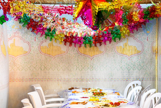 Colorful Sukkah decoration shiny garland and table. Happy family celebrate Sukkot.
