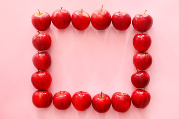 Frame made of ripe apples on color background