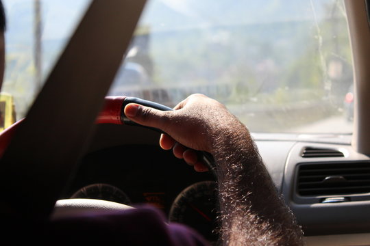 Man driving car holding stearing tightly