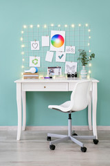 Comfortable workplace with mood board in room