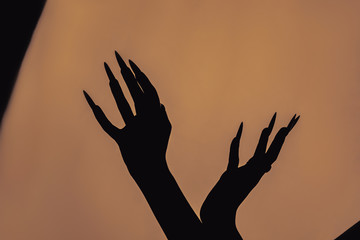 a girl with long hair in the image of a witch is trying to set herself on fire. rituals with candles for love spell and damage. expulsion of a bad spirit from the body.