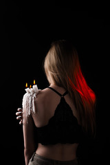a girl with long hair in the image of a witch is trying to set herself on fire. rituals with candles for love spell and damage. expulsion of a bad spirit from the body.