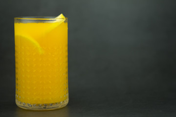 Orange juice in the glass on dark background