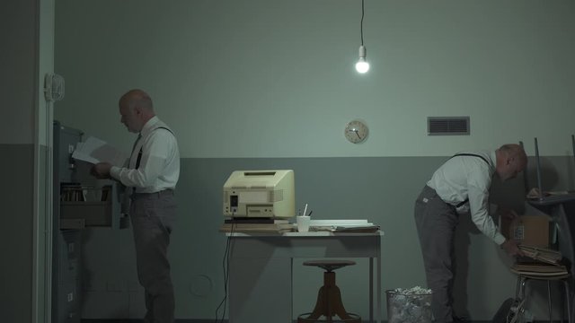 Multitasking office worker searching for files in his office
