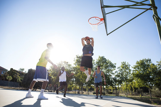 Group of people running and jumping while playing streetball