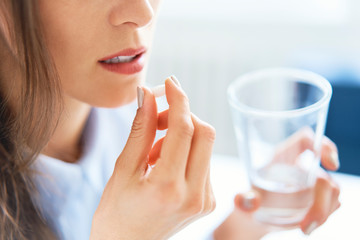 Close up of woman taking pill 