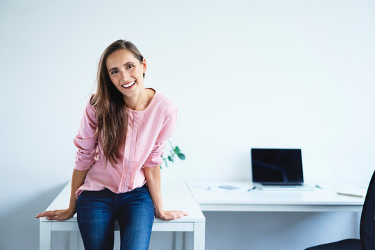 Young Woman Laughing And Smiling At Camera In Home Office