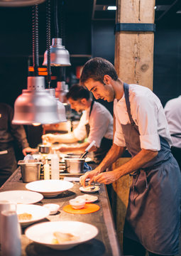 Chef serving food on plates in the kitchen, of a restaurant