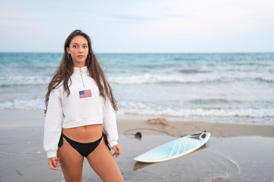 Portrait of young woman with surfboard on the beach - Powered by Adobe