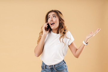 Portrait of amazed woman expressing surprise while talking on cellphone