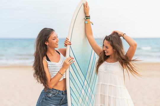 Two happy female, friends with surfboard on the beach