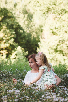Mother with her daughter in a flower meadow