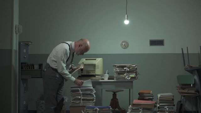 Disorganized businessman searching files in his office