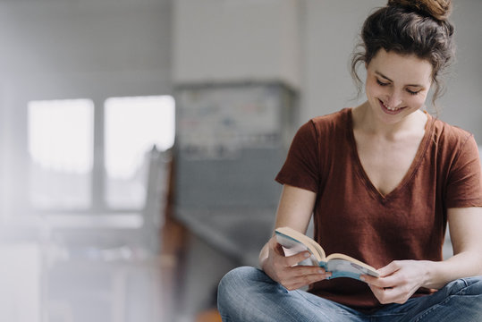 Smiling young woman reading a book