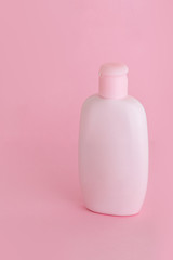 Organic natural cosmetic for baby, pink plastic bottle of bath cream, shampoo, lotion, shower gel, body milk on pink background. Mockup
