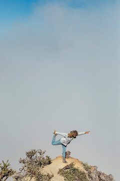 Woman practicing yoga on viewpoint, near Ijen volcano, Java, Indonesia