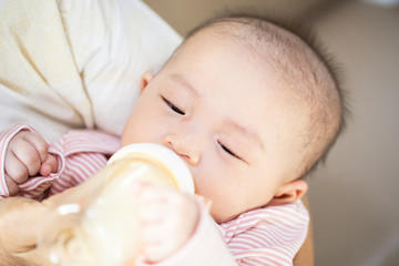 Asian baby happy in the room.Asian baby girl lying down on bed .Baby read book and play toy.