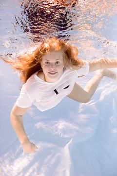 Portrait of teenage girl wearing t-shirt diving under water