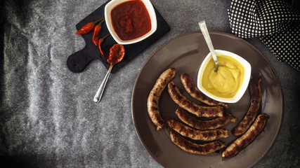 Grilled sausages with vegetables and hot spicy red pepper tomatoes sauce and mustard