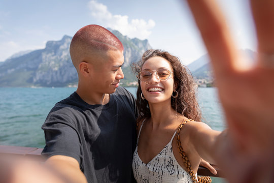 Young couple taking selfie in front of Lake Como, Lecco, Italy