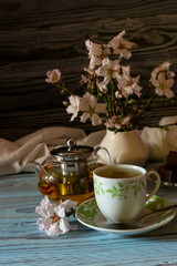 Useful, hot herbal tea, candy and flowering almond twigs close-up