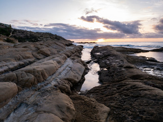  sunrise on rocky beach with orange light