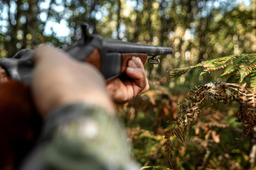 Finger on the trigger of a hunting rifle in the autumn forest close-up. The hunting period, the...