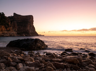  sunrise on beach with rocks in cala moraig