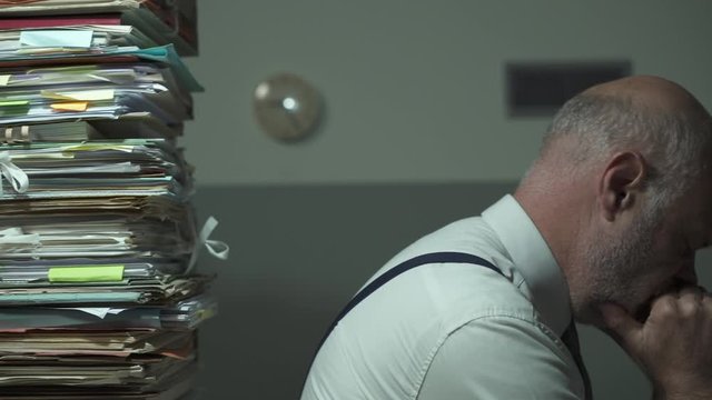 Depressed stressed businessman with lots of paperwork