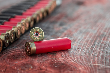 Hunting cartridges in patronage are lying on a wooden table close-up. The hunting period, the...