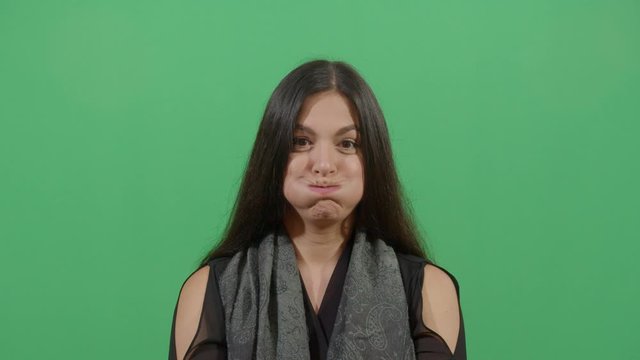 Woman Inflating The Cheeks. Studio Isolated Shot Against Green Screen Background