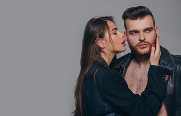 Couple passionate people in love. Passion fashion. Man brutal well groomed macho and attractive feminine girl long hair cuddling. Girlfriend passionate red lips and man leather jacket. Passionate hug