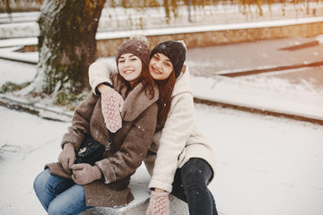 Obraz premium two bright and merry girls sitting in the frozen snowy park
