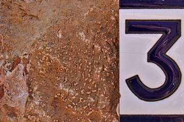 House number sign number three on a wall