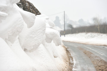 Snow drifts by the sides of  rural roads