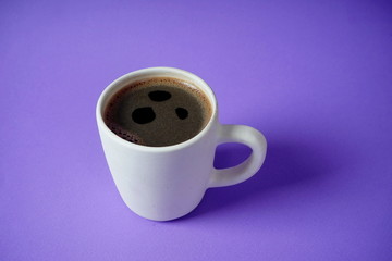White Cup with black coffee on lilac background. Rest, relaxation, tone.