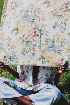 Woman sitting behind floral textile