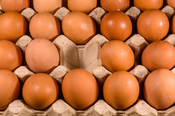 Pile of the hen eggs in paper tray on wooden table