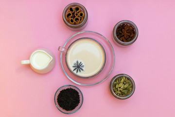 Obraz na płótnie Canvas Milk tea masala chai with ingredients on pink background, top view
