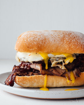 Close up view of beef brisket sandwich with eggs and ciabatta roll