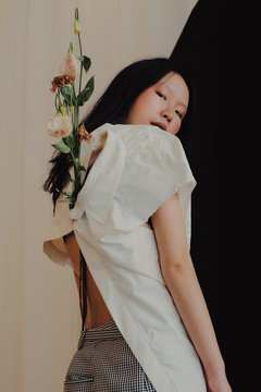 Portrait of woman in backward shirt with lilies on back