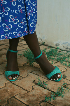 Low section of woman wearing sandals standing on pavement