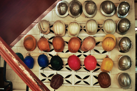 Variety of hardhats hanging on wall