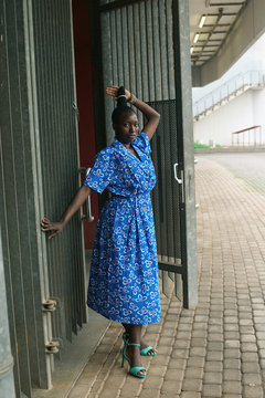 Portrait of woman in dress posing in front of door