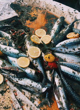 Top view of marinated mackerel fish with lemons garnished on it