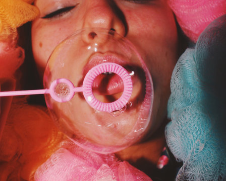 Close up of woman blowing a bubble